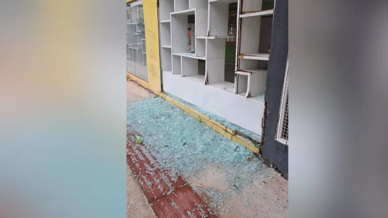 Bandidos estouram porta de loja no Centro e deixam calçada forrada de vidro