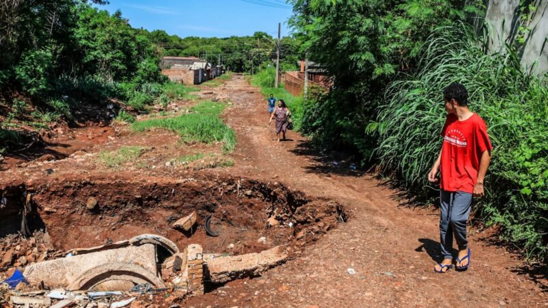 Moradores se arriscam para atravessar cratera que ‘engoliu’ rua no bairro Rouxinóis