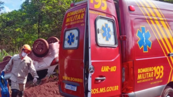 Motorista é retirada de veículo com ajuda de passageiro depois de carro capotar